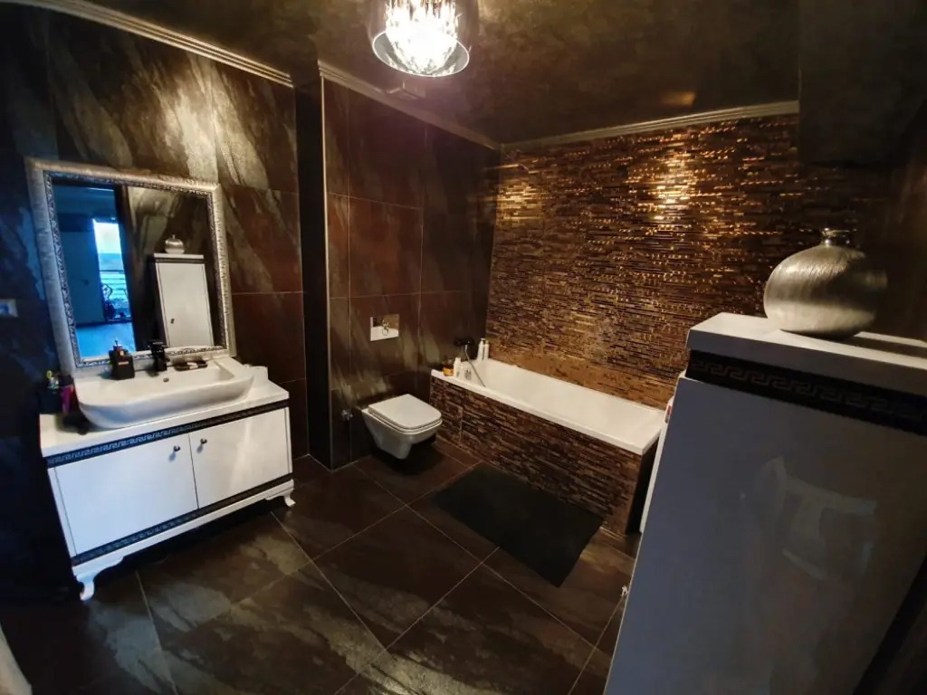 Proiect rezidențial baie cu mozaic decorativ metalizat și gresie în nuanțe de bronz în București